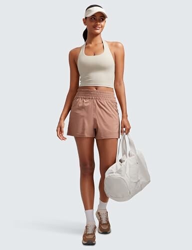 Mujer con ropa deportiva y bolsa blanca.