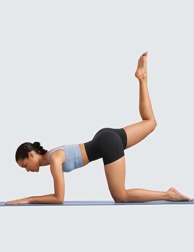 Mujer haciendo yoga en posición cuadrúpeda.